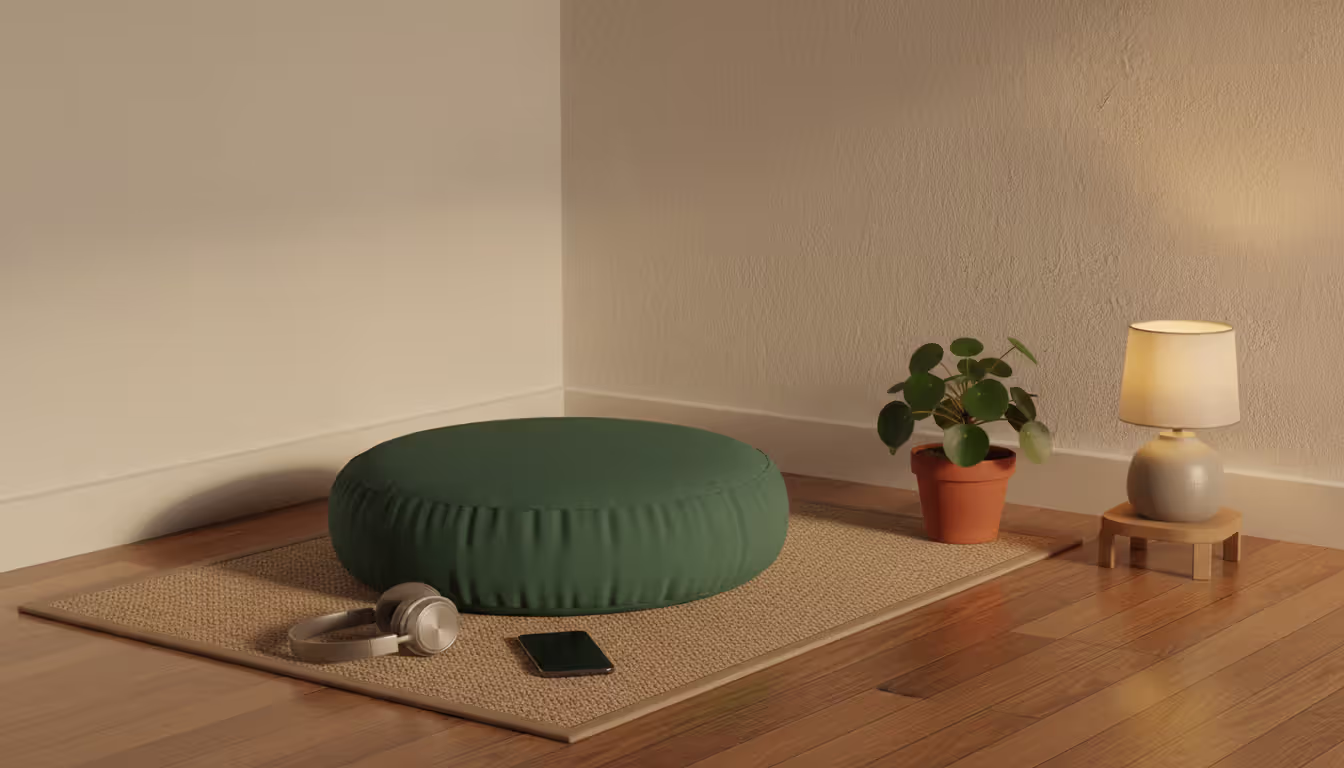 Cozy meditation corner with a floor cushion headphones and a smartphone placed face down next to a small potted plant in warm evening light