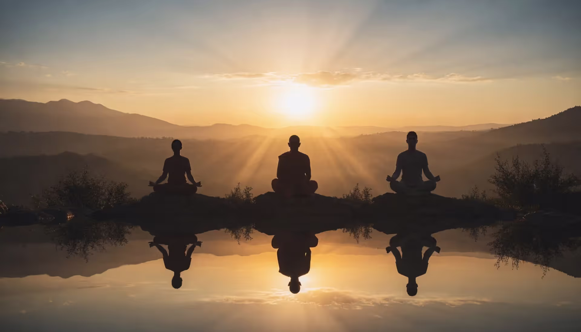 Silhouettes of people meditating in different poses against a warm golden sunrise sky, representing ancient and modern meditation traditions across cultures